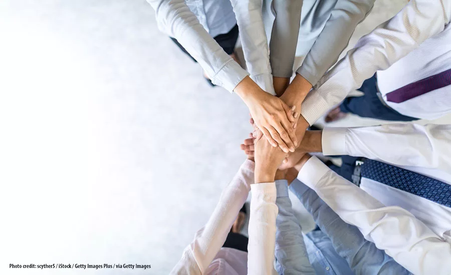 Photo of people's hands coming together like teamwork. 